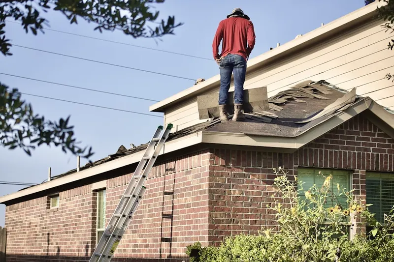 Professional roofer working on a residential roof in Addison